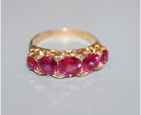 A yellow metal, graduated synthetic ruby and diamind chip set half hoop ring, size N/0.