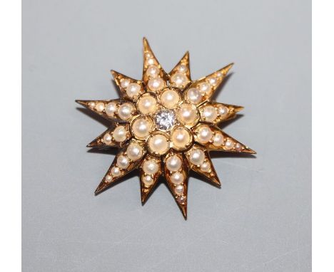 An Edwardian yellow metal, seed pearl and diamond set starburst brooch, 26mm.