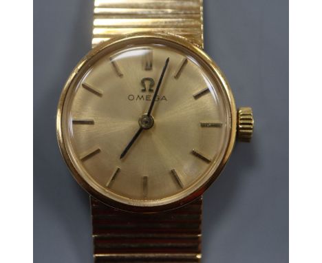 A lady's 9ct gold Omega manual wind wrist watch, on a 9ct gold Omega strap.