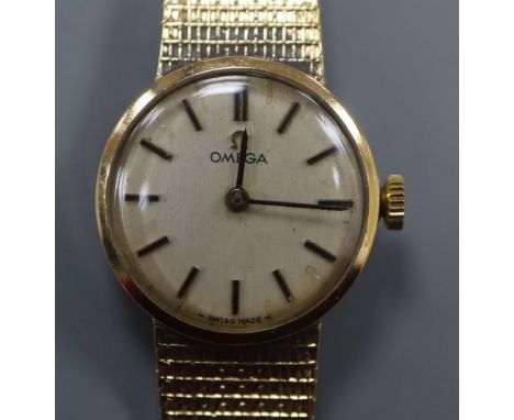 A lady's 9ct gold Omega manual wind wrist watch, on a 9ct gold Omega strap.