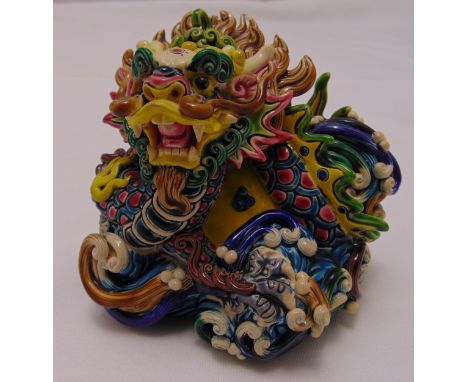 A Chinese polychromatic ceramic figurine of a stylised dragon,