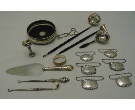 A quantity of hallmarked silver and white metal to include a wine bottle coaster, decanter labels, a toddy ladle, a candle sn