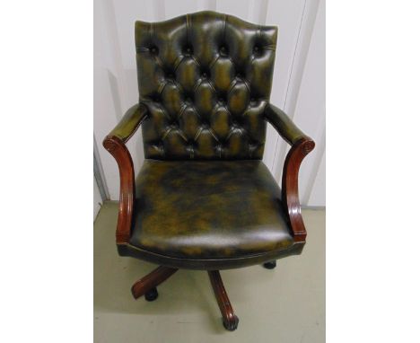 A leatherette button back directors chair with scroll arms on fluted swivel supports and original castors