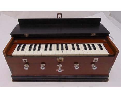 An Indian rectangular wooden cased Harmonium with five stops, pump action bellows and carrying side handles, retailed by H.V.