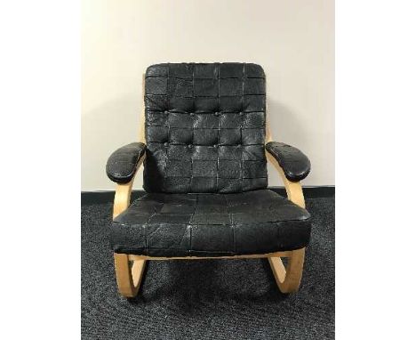 A late 20th century beech framed armchair in black button leather 