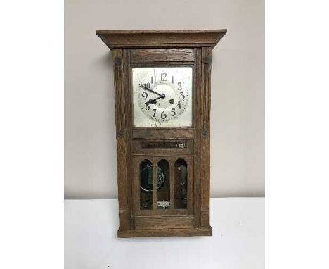 An Edwardian oak wall clock with calendar dial 