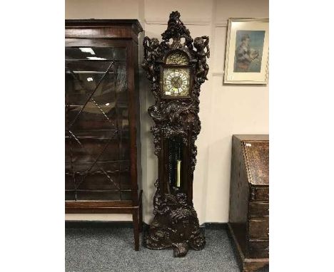 An ornate Art Nouveau style longcase clock with brass and enamel dial