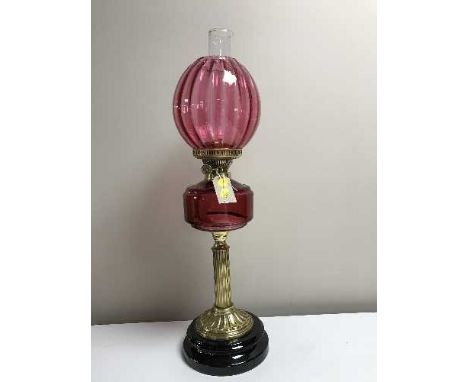 A Victorian cranberry glass oil lamp on gilt brass column 