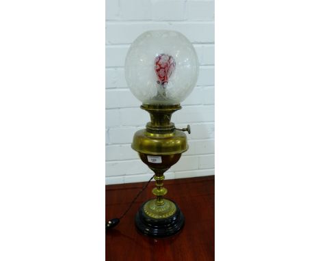 A brass oil lamp base, converted to electricity, complete with etched glass shade, height overall 57cm