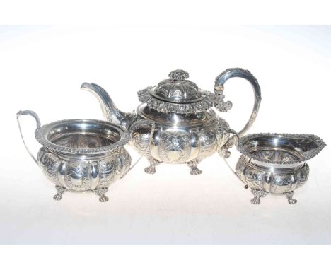 George IV silver three piece tea service, each circular lobed body with embossed decoration, having ornate border and on paw 