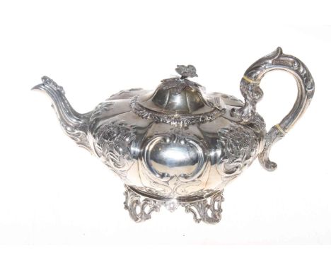 19th Century Irish silver teapot, of lobed form with embossed and chased decoration, cast finial and foot rim, Dublin 1846.