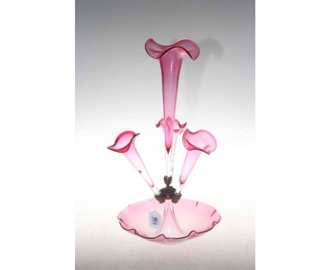 Ruby glass epergne with central flute and three branches raised on crimped rim base.