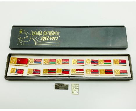 RUSSIAN COMMEMORATIVE SET OF SIXTEEN BASE ENAMEL BADGES 1917-1977 ANNIVERSARY OF OCTOBER REVOLUTIONIN PLASTIC BOX & ONE EXTRA