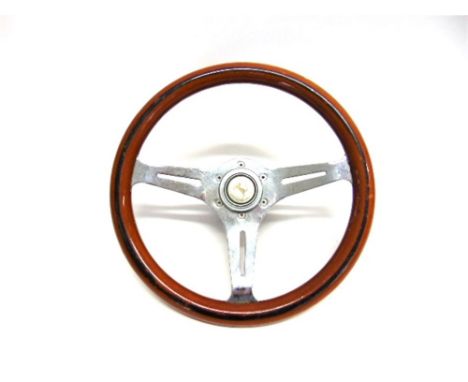 A SPORTS CAR STEERING WHEEL with a wooden rim, the central push-button horn with a Ferrari style prancing horse motif, 34.5cm