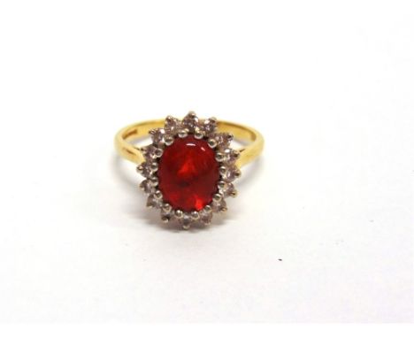 A FIRE OPAL AND DIAMOND 18 CARAT GOLD CLUSTER RING  the oval shallow cabochon with facetted base measuring approximately 8.5m