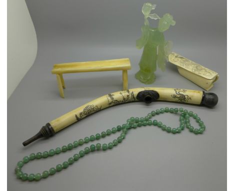 A carved bone container, a carved figure, a string of jade beads, a stand and a pipe 
