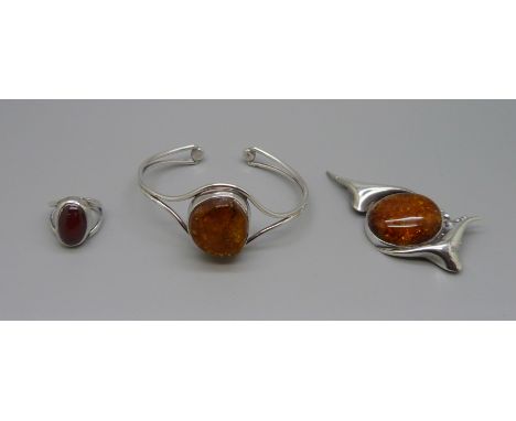 A silver and amber set bangle and brooch, and a white metal and amber set ring, O 