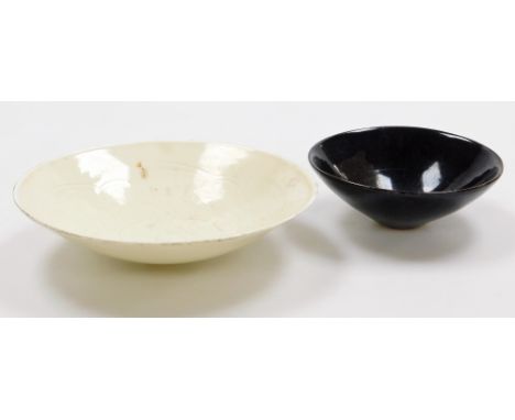 Two Chinese ceramic bowls, one faintly incised with dragons, 22cm diameter, the other with brown glaze and leaf design, 21cm 