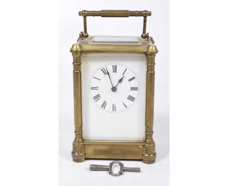 A late 19th/early 20th Century brass carriage clockThe four/glass clock enclosing white enamelled dial with black Roman numer
