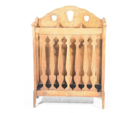 An early 20th Century oak stick standThe arched back with three shaped apertures above three compartments, supported on seven