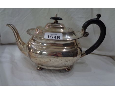 A silver oval teapot by Goldsmiths &amp; Silversmiths Company with hinged flip-top, set on ball feet - London 1918