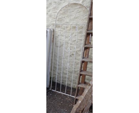 An old wrought iron single garden gate of tall form