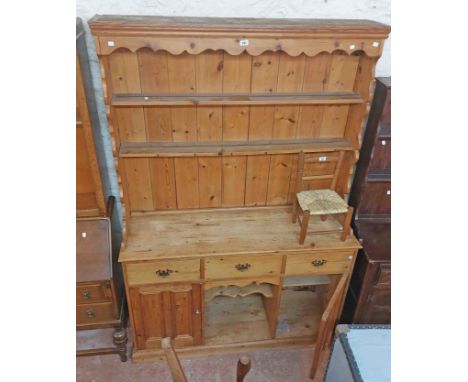 A 1.36m antique style pine two part dresser with two shelf open plate rack over a base with three frieze drawers, central rec