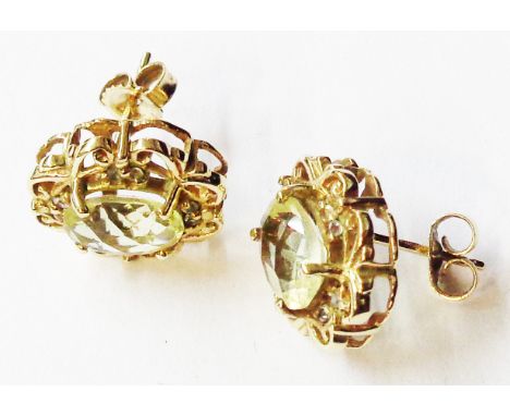 A pair of hallmarked 375 (9ct.) gold oval panel ear-rings, each set with a central citrine within a decorative pierced and di