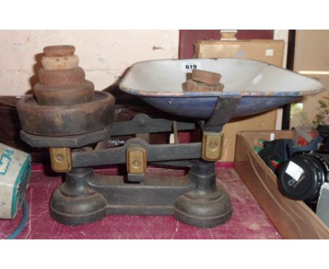 A set of kitchen scales with enamel tray and cast iron weights