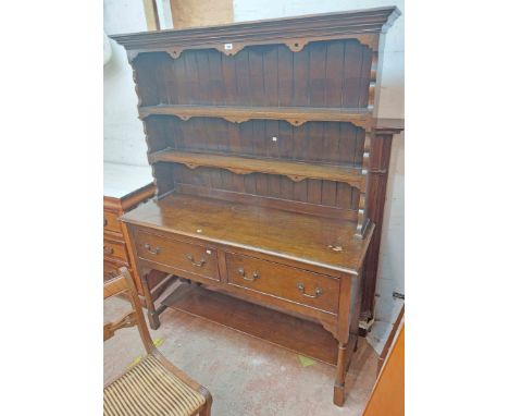 A 1.37m 20th Century Williams &amp; Cox polished oak two part dresser with two shelf open plate rack over a base with two sho