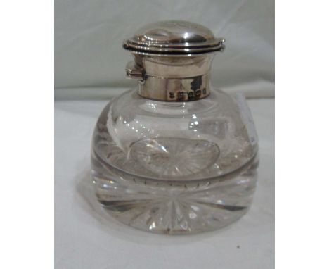 A silver flip-top glass inkwell with star cut base and nib well to top - dents and initial to lid