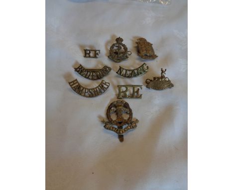 A bag containing a quantity of military cap badges including Ordnance, The Hertfordshire Regiment, Royal Engineers, North Lan