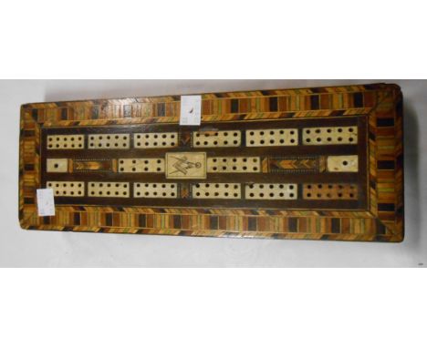 An antique cribbage board with allover marquetry work decoration with inset bone panels and a central panel depicting a Mason