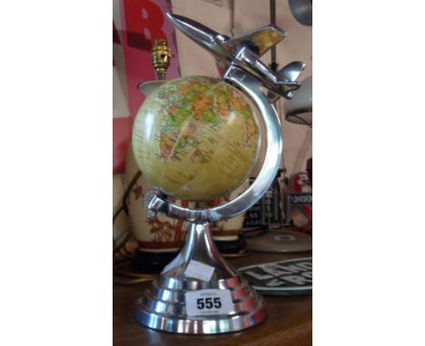 An Art Deco style globe of the world with aeroplane to top