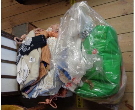 A crate containing a quantity of textiles including material, curtains, tiebacks, etc.