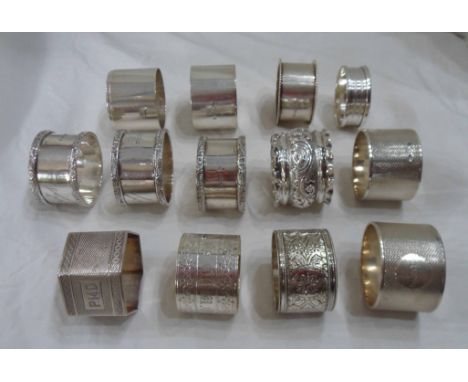 A collection of silver napkin rings including a pair with engine turned decoration and named cartouches, three Walker &amp; H