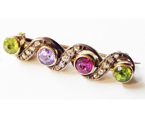 An old yellow metal multi-gem set bar brooch with two peridots, amethyst and tourmaline within diamond chips