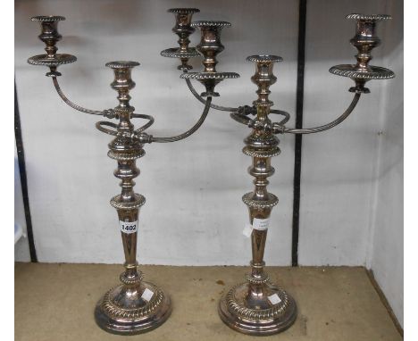 A pair of 53cm high old silver plated twin branch three light candelabra with gadrooned decoration and loaded circular bases 