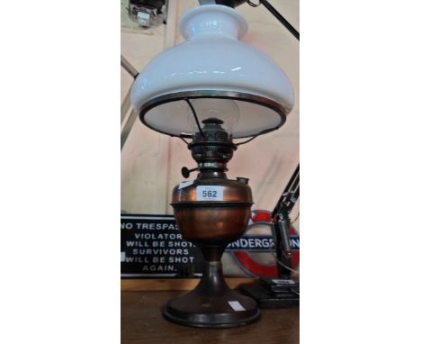 A brass oil lamp with coppered finish and white opaque glass shade - shade has chip to rim