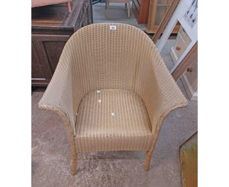 A vintage Lloyd Loom tub chair with beige finish and original paper label