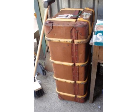 A vintage cane bound travelling trunk with weather proof canvas and applied travel labels from various shipping lines and Lus
