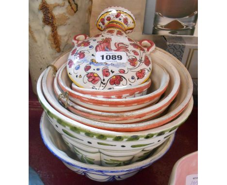 A quantity of modern Italian tin glazed wall hanging jelly moulds and a similar flask