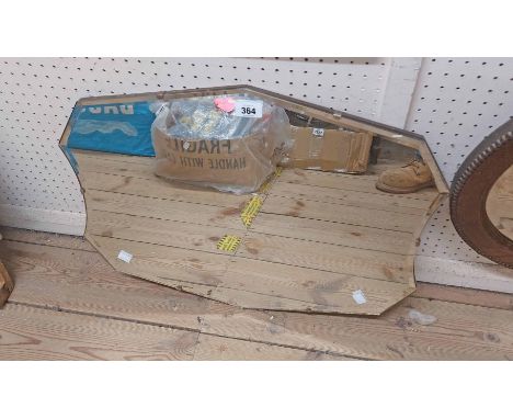 A vintage frameless wall mirror with shield shaped plate