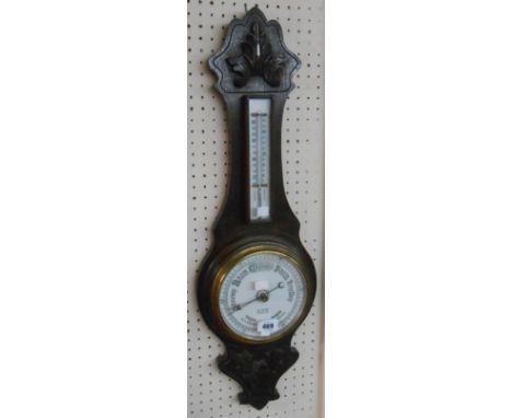 A late Victorian carved oak cased banjo barometer/thermometer with ceramic scale and dial marked for H. Cross, Tiverton. with