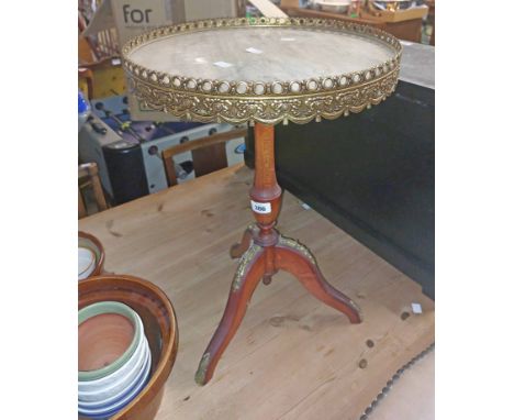 A reproduction marbled top wine table with brass border, set on turned pillar and tripod base