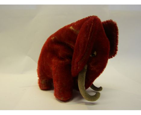 A C.1912 Steiff red mohair mammoth with white felt crescent and black boot button eyes, white felt tusks, button missing, sta