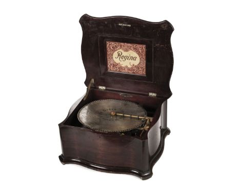 * Mechanical Music. An American Regina tabletop polyphon, the shaped stained hardwood case with a hinged lid inset with trade