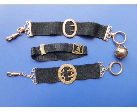 A Masonic folding yellow metal ball pendant on ribbon and two other gold mounted black ribbons. (3)