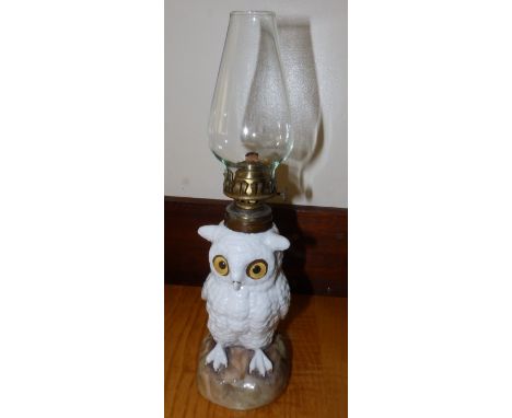 A 19thC Continental porcelain snowy owl oil lamp with glass eyes.