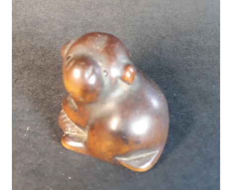 A 19thC Japanese wooden netsuke study of a puppy.